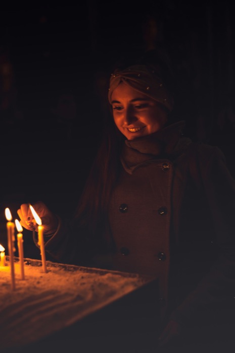 Woman smiling beside candles