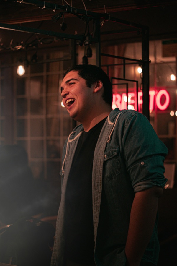 Man laughing under bar lights